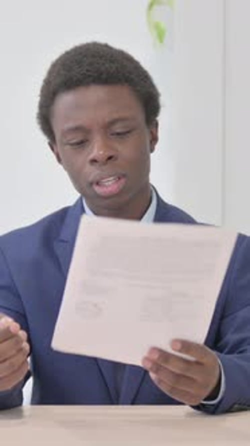 Young African Businessman Feeling Upset after Reading Documents, Paperwork, Vertical Video