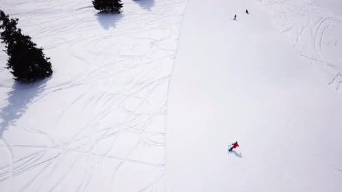 4k aerial footage, drone following skiers on ski slope in skiing region. Skiers skiing downhill the