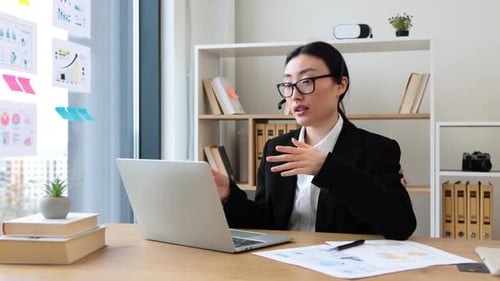 Young Woman Video Conferencing at Desk in Bright Office