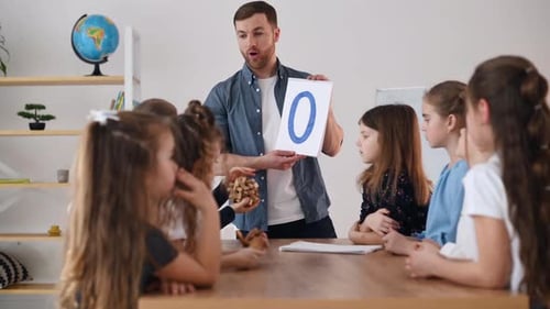 Learning O letter. Group of children students in class at school with teacher