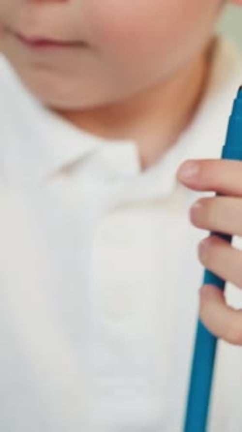 Child Opening Marker and Turning Pages of Book