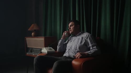 Homme dans le loft rétro et parlez avec un vieux téléphone fixe