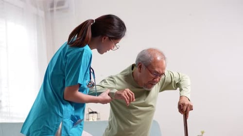 Caregiver Assisting Senior Man with Walking Cane