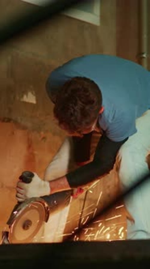 A Focused Craftsman Using a Cutting Tool to Create Sparks in a Workshop Demonstrating Skill