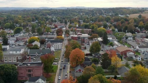 Rising aerial establishing shot of Anytown USA. Small town in America with colorful leaves. Church,