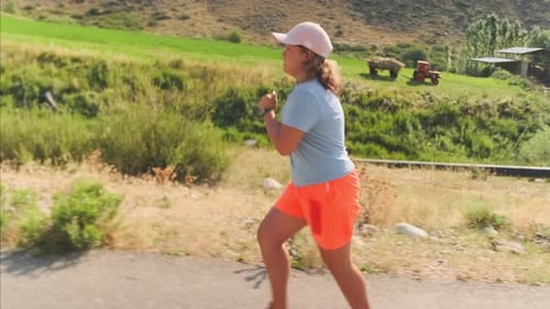 Woman Jogging on Rural Road on Sunny Day