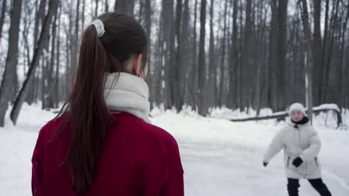 Child Approaches Adult in Winter Snowy Forest