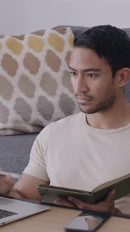 Man works at home, laptop, notebook and phone