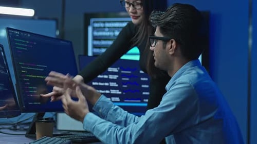 Developers Solving Code Problem Together In Dark Office
