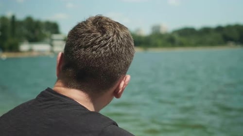 Man Looking at Lake Water on Sunny Day
