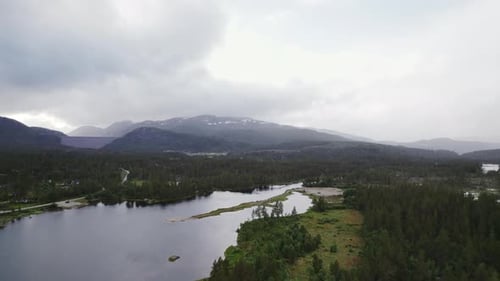 Aerial View of Lake Surrounded by Forest and Mountains
