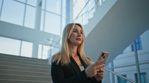 Focused Businesswoman Using Smartphone in Modern Office Interior Closeup