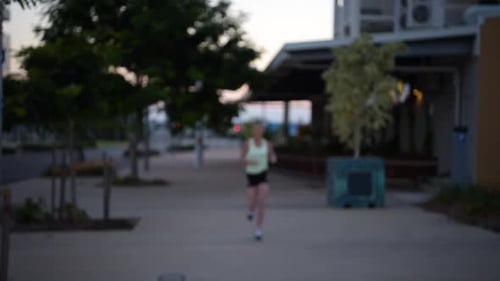 Woman running from out of focus to the camera.