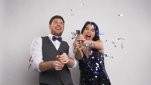 Happy Couple Celebrates with Confetti Poppers