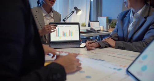 Business Team Analyzes Financial Data at Night