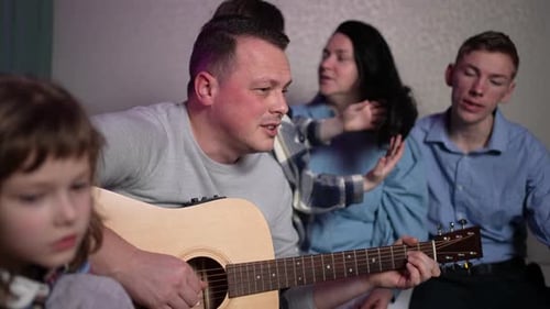 Family sings together with guitar music at home