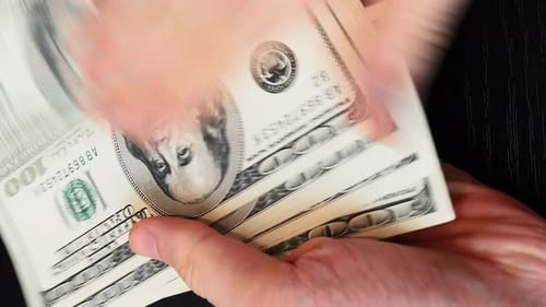 Close up of hands scattering cash banknotes.