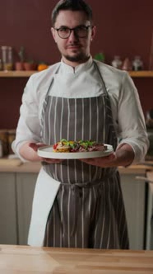 Chef Proudly Presents a Gourmet Dish Indoors