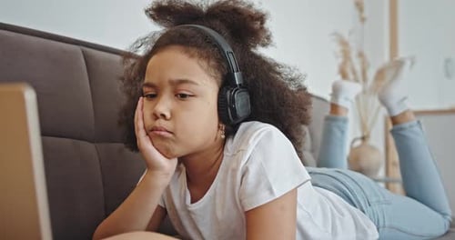 Mixed Race Girl Using Laptop on Sofa