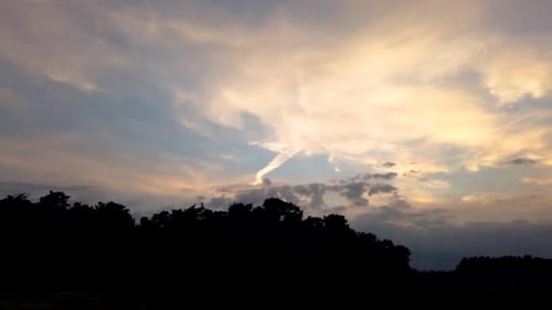 Timelapse of sunset in city with few clouds in the sky and orange teal tones. SERIES Red orange suns