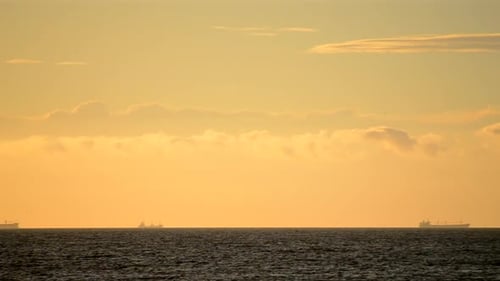 Sunset over the Ocean with Distant Cargo Ships
