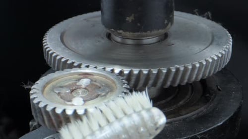 Toothbrush Cleaning Silver Gears in a Close Up Shot