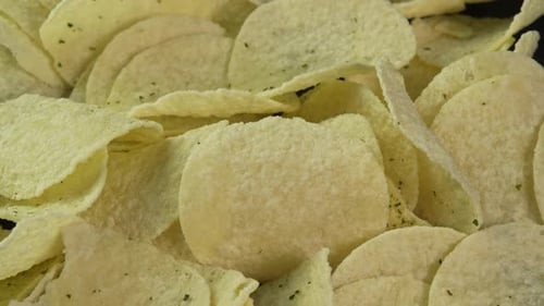 Close up potato chips spinning background. Snack for drinks. Golden fried potatoes. Crispy snacks