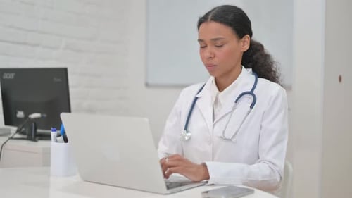 African Female Doctor Smiling at Camera in Clinic