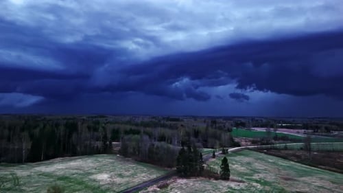 Dark Storm Clouds Roll in Over the Quiet Countryside, Illuminated by Flashes of Distant Lightning -