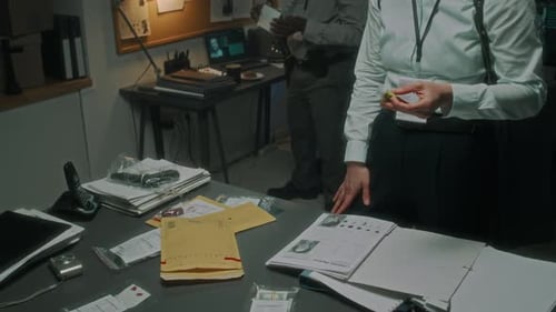 Detectives Examine Evidence in Dark Office