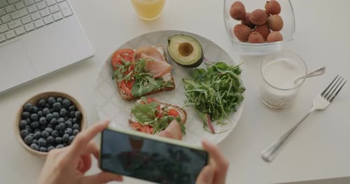 Closeup of Female Hand Taking Photo of Tasty Healthy Meal Using Smartphone Camera Enjoying Food