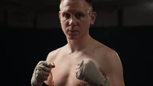 Portrait of Focused Boxer with Wrapped Hands Preparing for Match