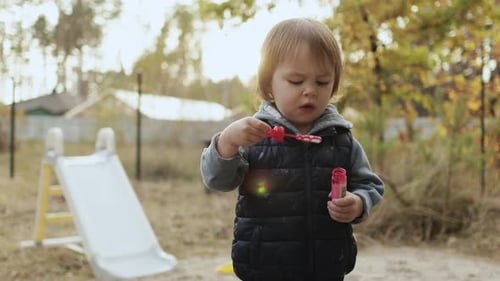 Child Blowing Bubbles in Backyard