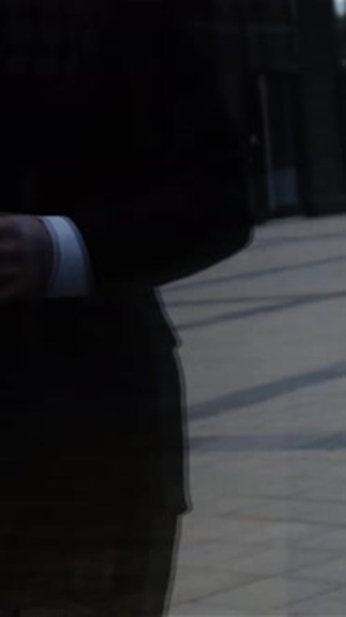 Man in Suit Talking on Phone with Coffee