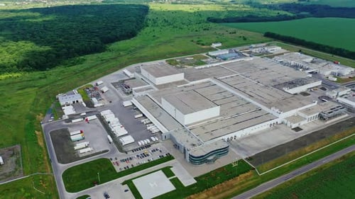 Large industrial complex. Modern factory surrounded by beautiful green summer landscape.