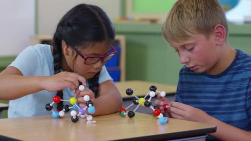 Enthusiastic elementary students build science models in school classroom