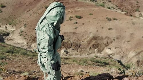 An Ecologist a Biologist in a Protective Suit is Studying the Area to Conduct Soil Quality Control