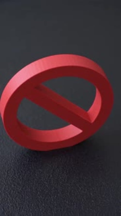Red No Symbol Spinning Slowly on Dark Surface