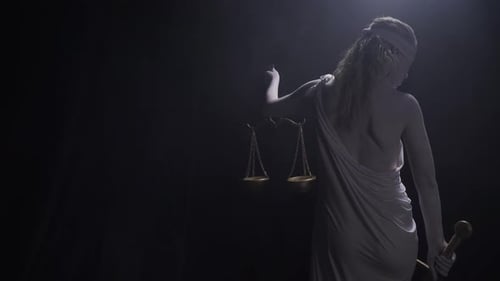 Justice Statue Holding Scales in Dark Studio