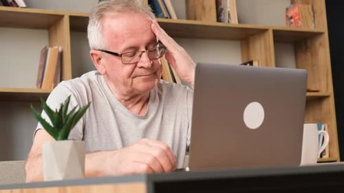 Senior Man Using Laptop at Home