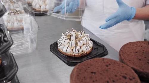 Baker Packing MeringueTopped Cake Into Clear Takeout Container Bakery and Confectionery Production