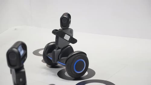 Small autonomous robot moves to the center and stops, a second robot is observing the area