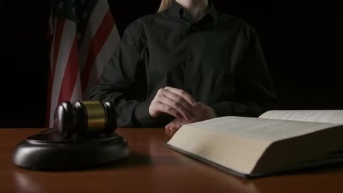 Person Points to Law Book in Court Setting