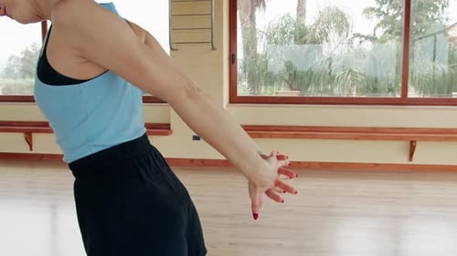 Woman Warming Up by Stretching Arms in Studio