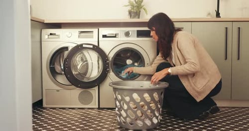 Woman Doing Laundry at Home in the Laundry Room