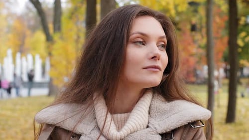Young Woman Looking Around in Autumn Park