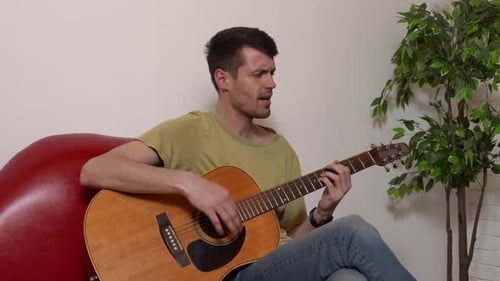 Man Playing Acoustic Guitar Indoors
