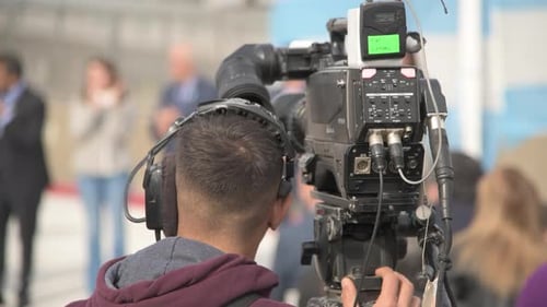 Die Arbeit eines Kameramanns in einem politischen Akt hinter seinem Rücken filmen