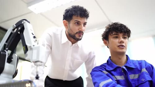 Los ingenieros inspeccionan y revisan la máquina de los robots de soldadura de máquinas de brazos automatizados en la fábrica.