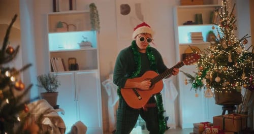 Man in Santa Hat Playing Guitar at Christmas